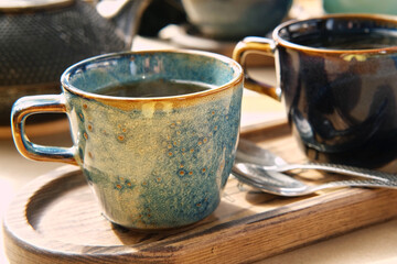 Brewing and Serving Tea. Teapot Pouring Green Tea in Blue Ceramic Cup on Wooden Cafe Table. Two Pottery Handmade Mugs Early in the Morning. Trendy Authentic Porcelain Set. Breakfast Concept. Tea Time
