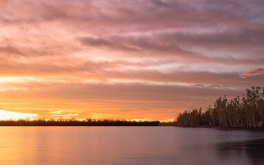 Fototapeta na wymiar Sunrise with clouds over a calm lake in the Australian countryside.