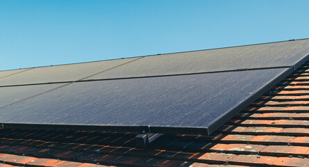 Solar panels on roof covered with dust during dry summer month.