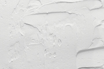 Decorative white putty background. Wall texture with filler paste applied with spatula, chaotic...