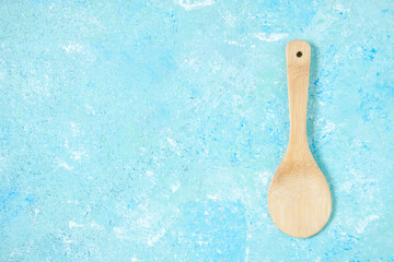 top view round wooden spoon on blue background with copy space