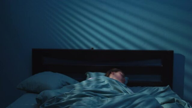 Insomnia and nightmare concept. Shocked scared woman waking up from a nightmare in her bed at night