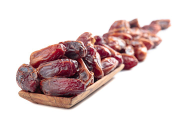 Dates in a wooden dish isolated on a white background.