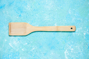 top view wooden spatula on blue table with free space