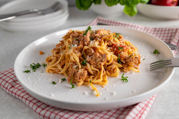 Tagliatelle with tuna, tomatoes, herbs and parmesan cheese on a plate