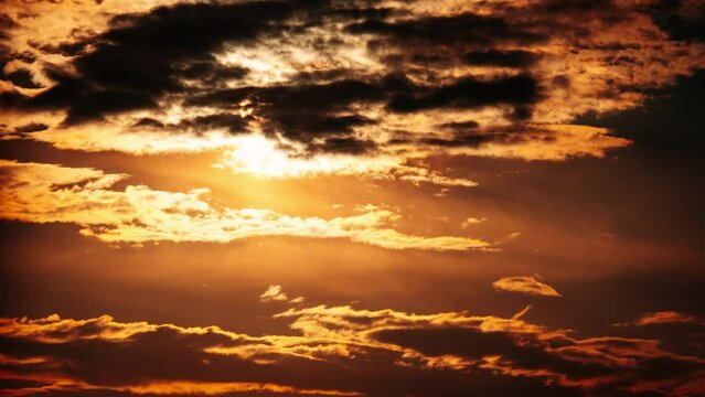 Awesome sunset moving down in orange sky with clouds, Timelapse. Bright orange sun moves down over the horizon behind the layered clouds. Epic cloud space, vibrant color. Time Lapse. Beautiful sundown