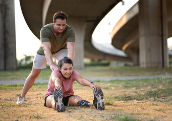 Exercise woman with prosthetic leg and stretching with caucasian friend in the park	