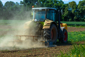 tractor grinding the dry soil on a field