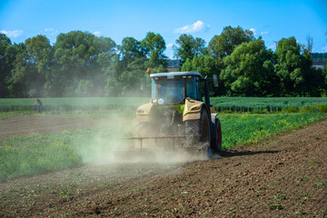 dust rising up as tractor grinds field