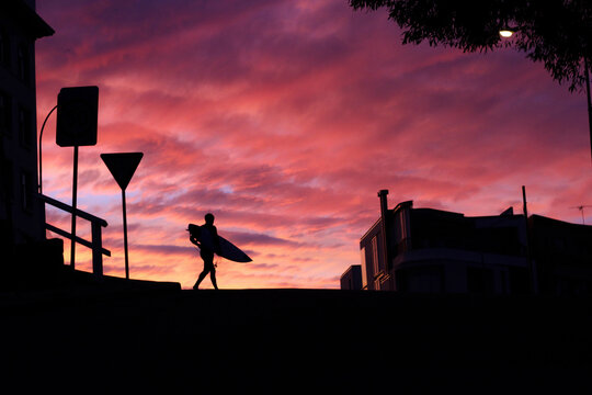 Silhouette of a surfer with a surfboard