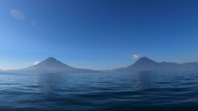 Traveling by boat across Lake Atitlan with Volcanoes in distance, Guatemala, Central America