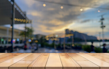 wooden table top with lights bokeh on blur restaurant background.