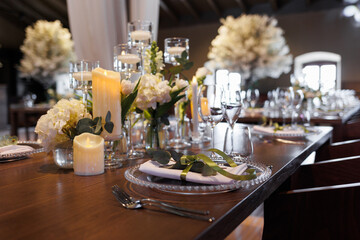 Wedding decorations. Served wedding table with transparent plates, green napkins, decorative fresh white flowers, candles and. Celebration details, wedding outdoor	
