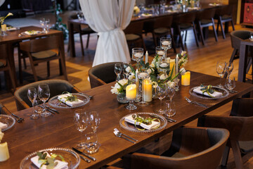 Wedding decorations. Served wedding table with transparent plates, green napkins, decorative fresh white flowers, candles and. Celebration details, wedding outdoor	
