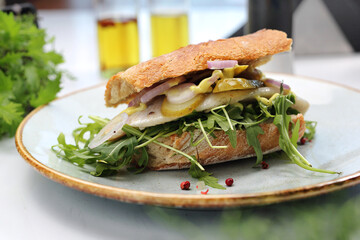 Sandwich with cheese, pickled cucumber, arugula and onion, selective focus, close-up.