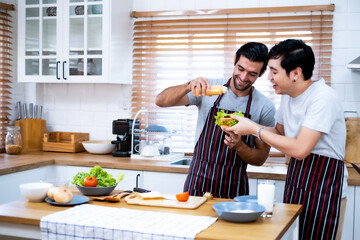 A couple of love preparing meal together with enjoyment, happiness and laughing in kitchen at home. Gays lover helping each other making breakfast.