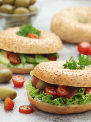 Sesame bagels with tomatoes, ham and olives