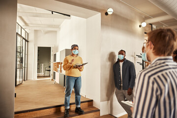 Businesspeople in face masks talking in an office