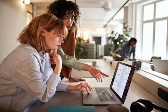 Businesswomen going over data on a laptop