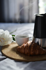 coffee and croissant in the bed with peony