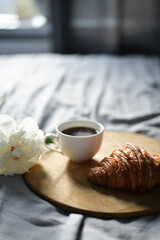 coffee and croissant in the bed with peony