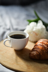 coffee and croissant in the bed with peony