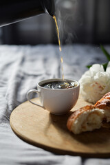 pouring cup of coffee in the morning in bed