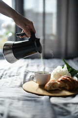 pouring cup of coffee in the morning in bed