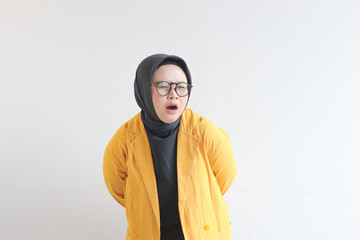 Beautiful young Asian Muslim woman, wearing glasses and yellow blazer having backache