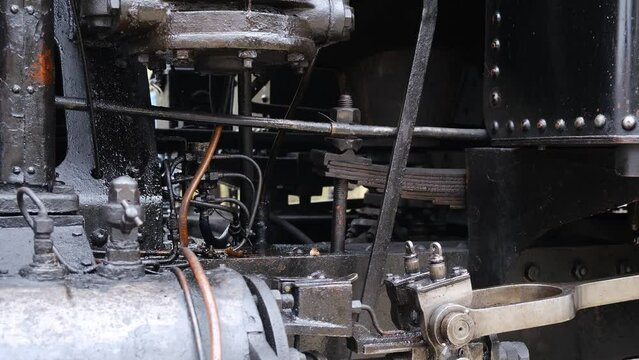 Detail shot of steam train engine with smoke. Black train composition, waiting on a station. 4K