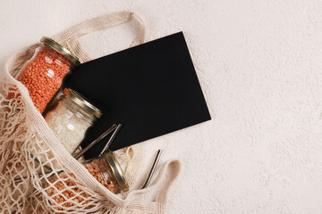 Zero waste lifestyle concept.Responsible consumption, healthy vegetarian food. black board for text and mesh , glass jar with food, reusable straws