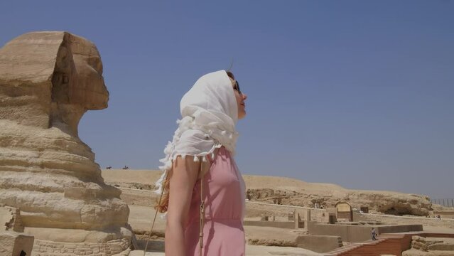 Young woman standing in front of the Great Sphinx of Giza.