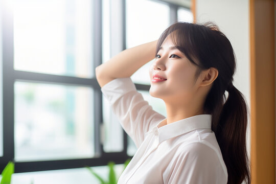 Asian woman taking a break and stretching in the office, asian woman working, close up depiction, digital photo, portrait, looking at camera, natural light, affinity, bright backgr Generative AI