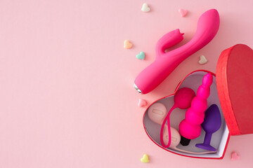Concept of erotic pleasure toys. Top view of vibrator, butt plug, vaginal balls and heart shaped...