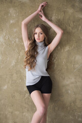 Young fashion woman posing near grey wall