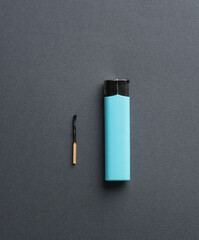 Lighter with match on dark background