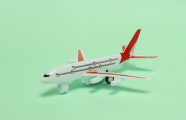 Fototapeta na wymiar Travel, tourism or voyage concept. Model of a passenger plane on green background