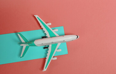 Travel, tourism, voyage concept. Model of a passenger plane on pink background with a blue runway. top view