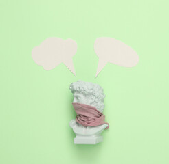 Bust of David with cloth-wrapped face and dialog clouds on green background