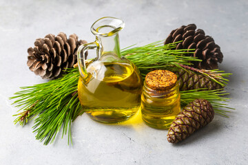 Pine turpentine essential oil in glass bottle with pine coniferous leaves and pine cone. Kiefer...