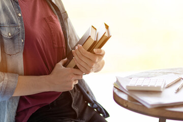 Young woman holding law book in her hand to review and understand law before taking exam to become...