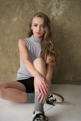 Young fashion woman posing near grey wall