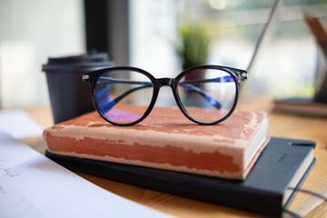 eye glasses placed on the desk are eye glasses that are prepared for people with farsightedness to...