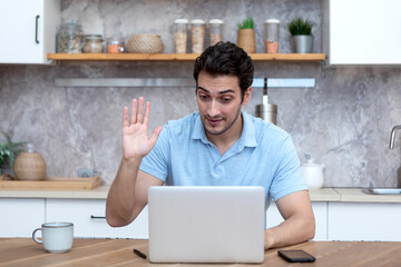 Young happy man looking at laptop and talking on video call. Online dating concept