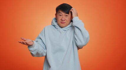 No idea, I dont know answer. Puzzled clueless uncertain asian handsome man raising hands in...