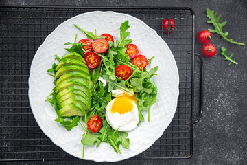avocado salad poached egg arugula, tomato, green salad leaves meal food snack on the table copy space food background rustic top view 