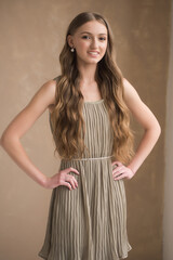 Fototapeta premium Fashion young woman wearing grey clothes posing on grey background