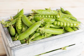 Composition with fresh green peas on wooden table