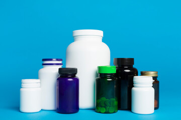 Plastic bottles for vitamins on color background