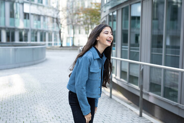 young teen girl laugh heartly in urban city while stand on street and have fun with her pretty joyful smile show happiness and embrace carefree spirit, confidence and positivity